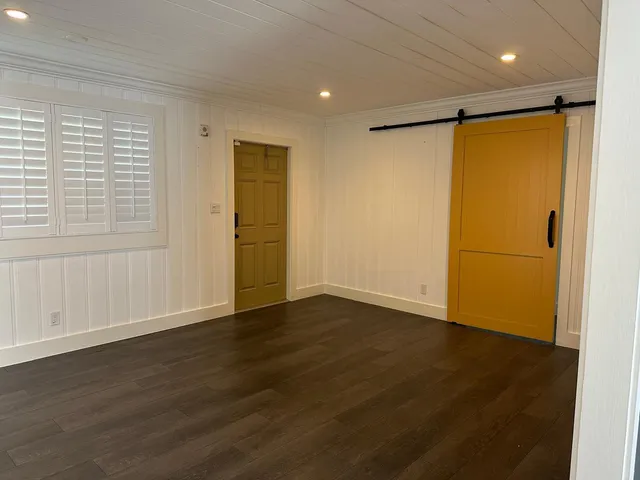 an empty room with wooden floor and a window