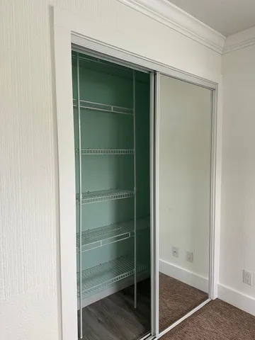 a view of walk in closet with empty racks
