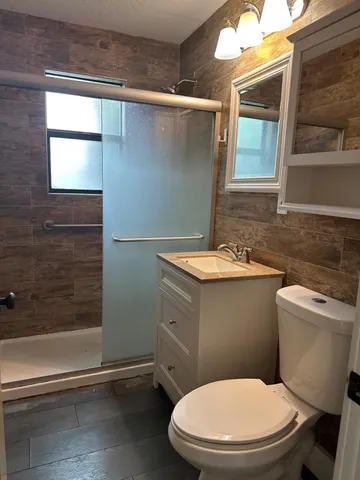 a bathroom with a sink a toilet a mirror and window