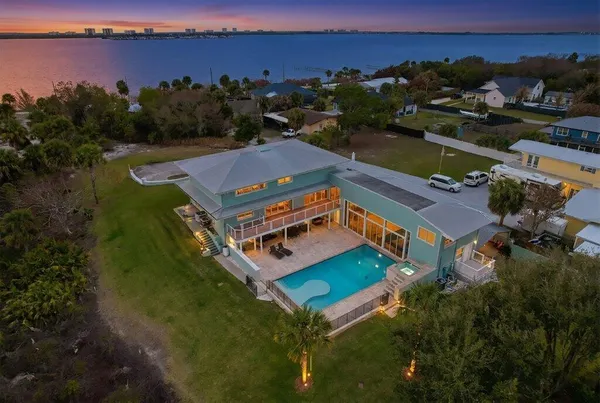 an aerial view of a house with a garden and lake view