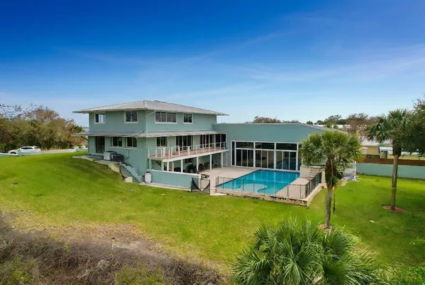 a view of a house with pool and chairs