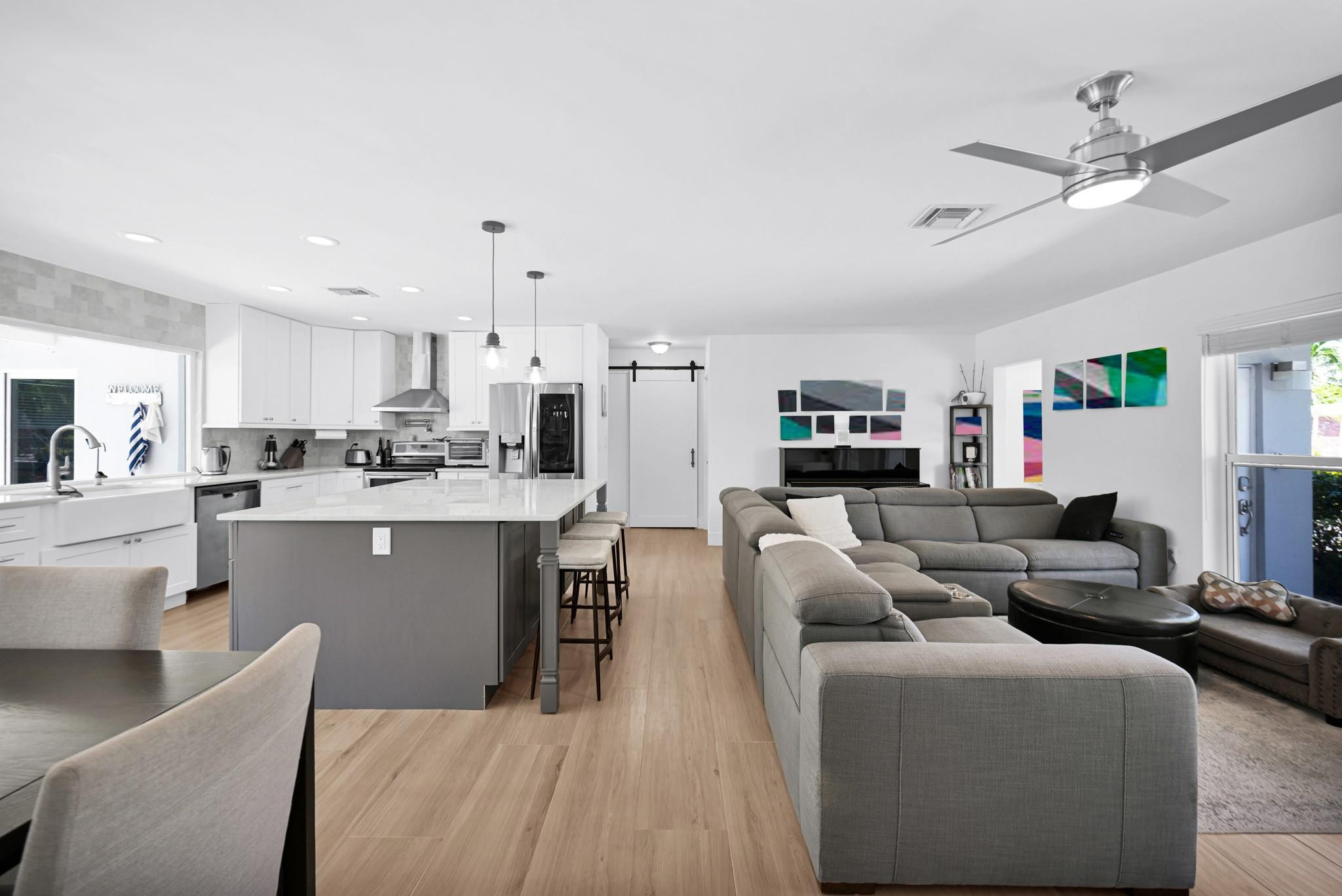 252 Southwest 14th Place Boca Raton, FL 33432 - Photo 49 of 49 a living room with couches a fireplace and kitchen view with wooden floor