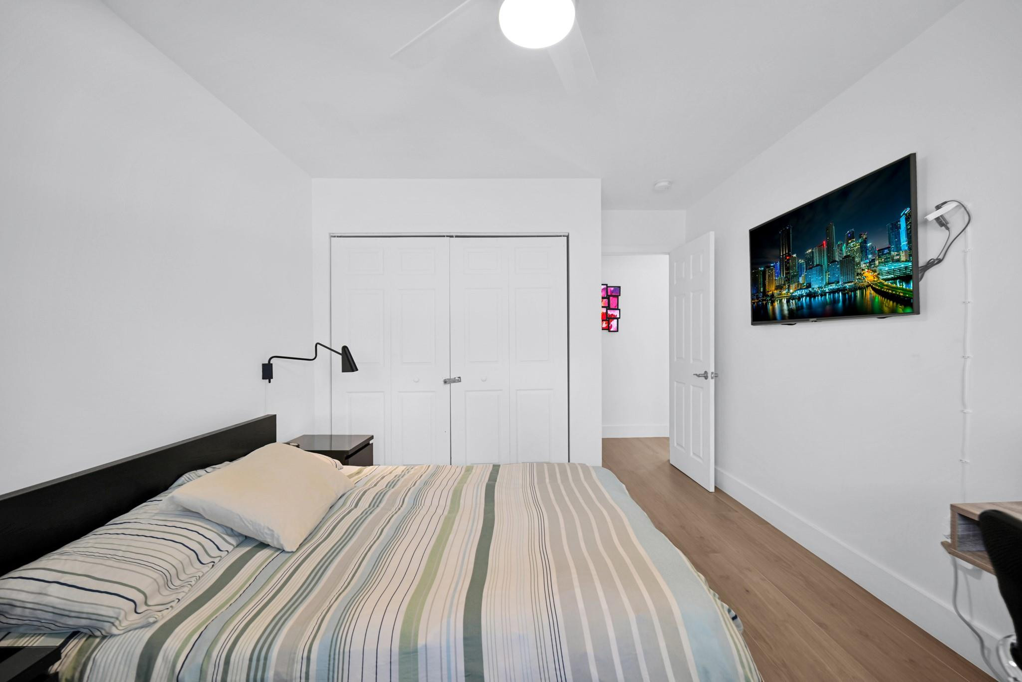 252 Southwest 14th Place Boca Raton, FL 33432 - Photo 24 of 49 a bedroom with a bed and a flat screen tv