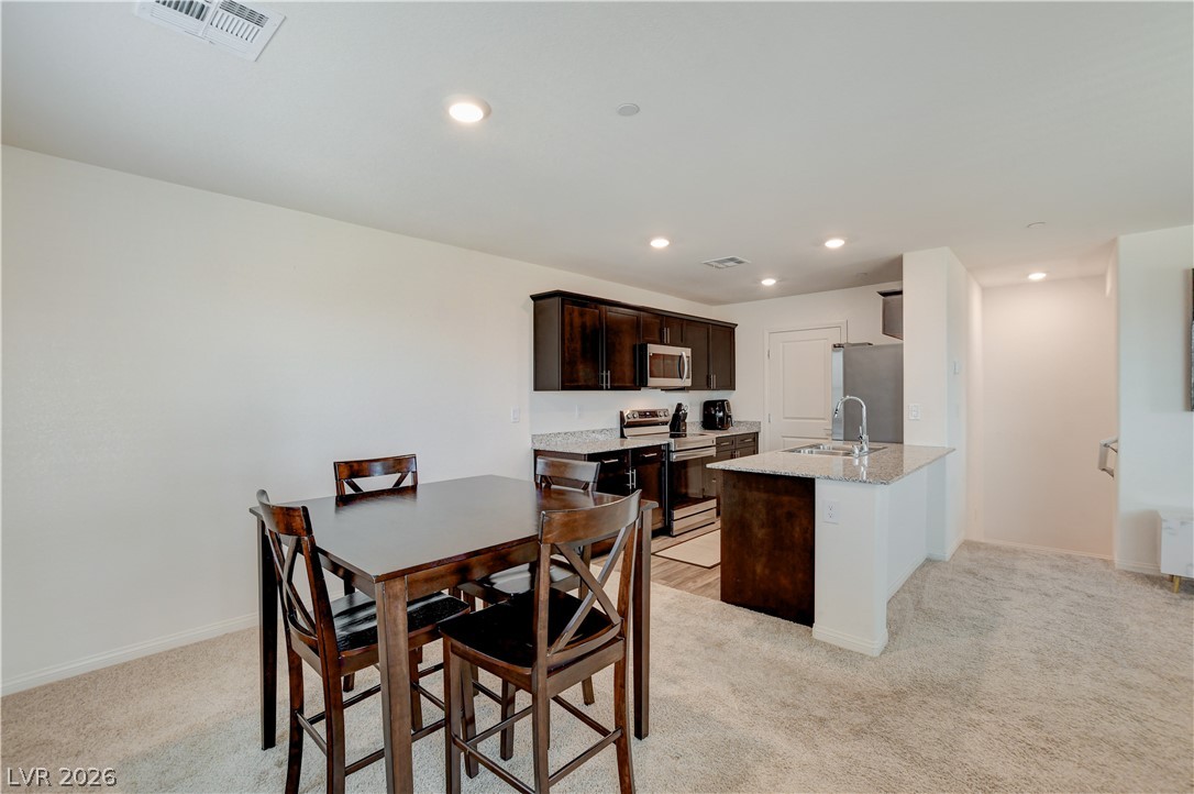 6924 Spicy Merlot Street North Las Vegas, NV 89086 - Photo 11 of 83 Granite counters and stainless steel appliances complete this contemporary kitchen and dining space.