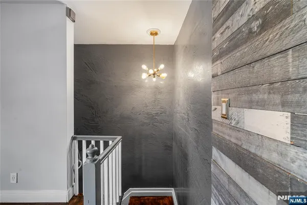 a bathroom with a light fixture a mirror and a shower