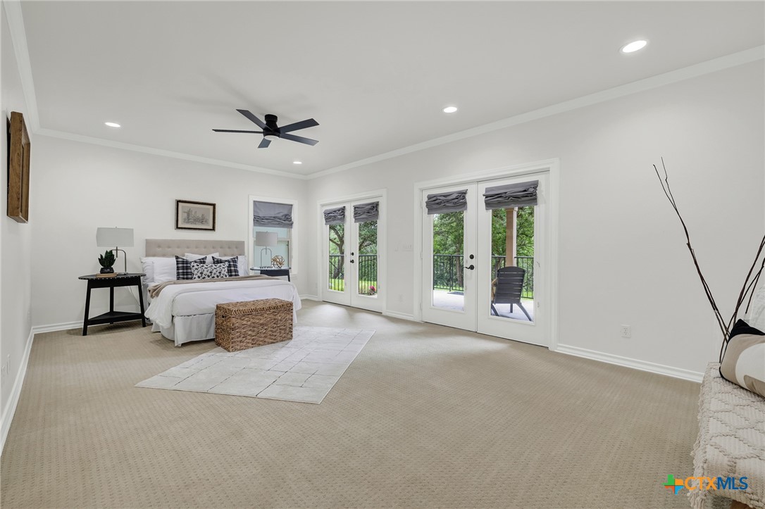 1029 Gruene Road New Braunfels, TX 78130 - Photo 19 of 48 a spacious bedroom with a large bed and a chandelier