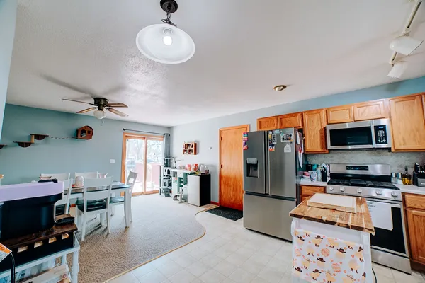 a kitchen that has a lot of cabinets a sink and appliances