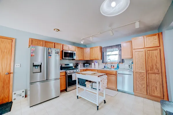 a kitchen with stainless steel appliances a refrigerator sink and cabinets