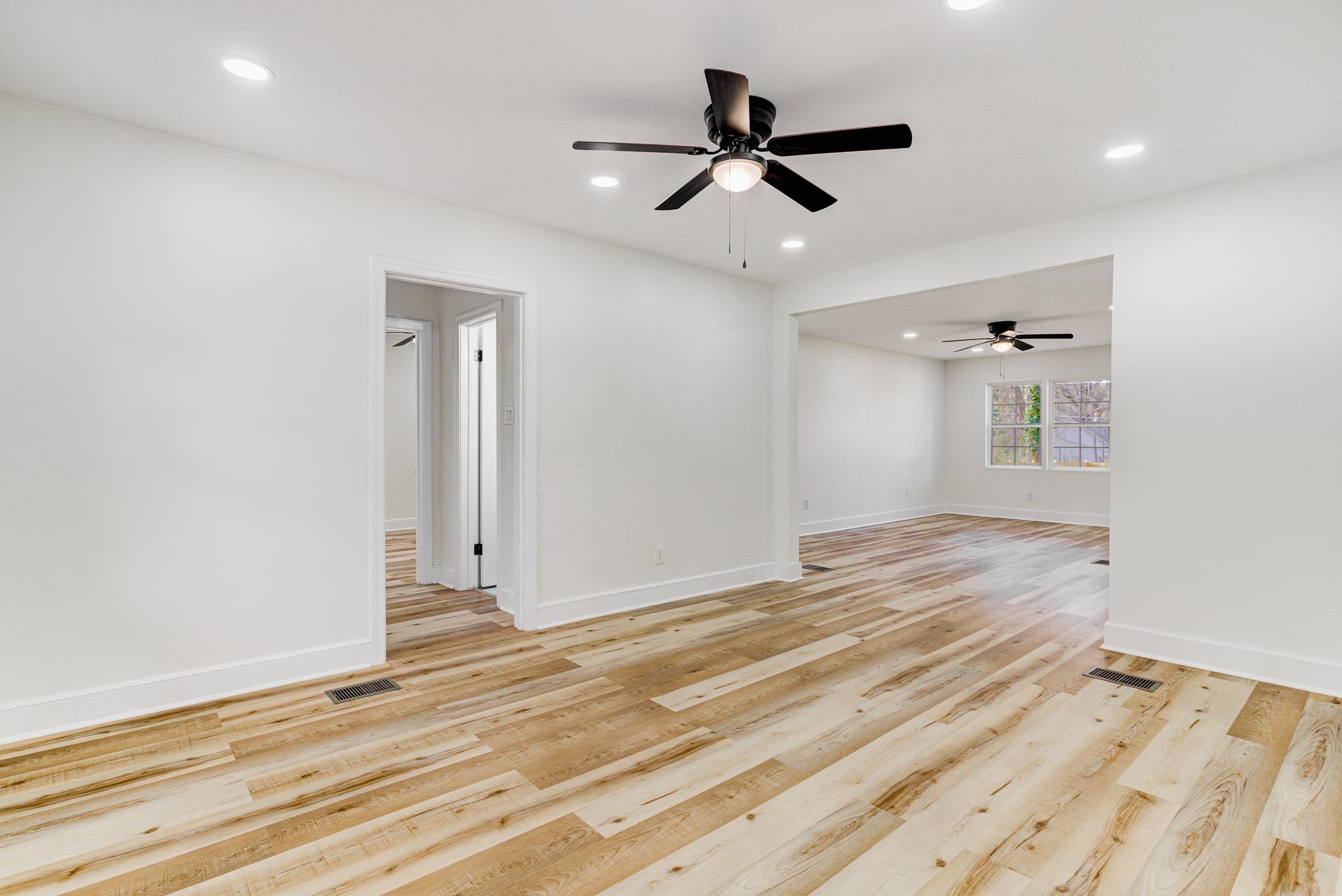 3438 Vanuys Road Memphis, TN 38111 - Photo 8 of 32 an empty room with wooden floor ceiling fan and windows