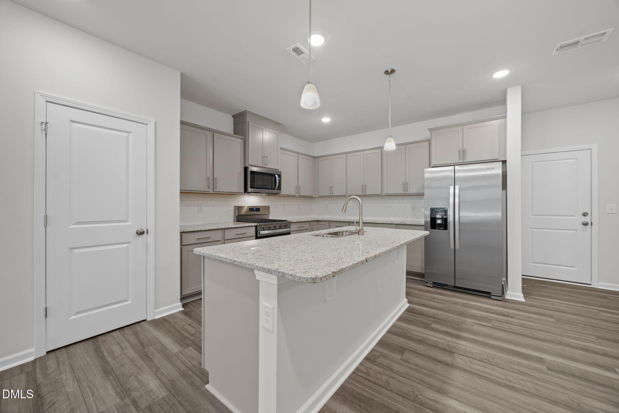 202 Fosterton Cottage Way Raleigh, NC 27603 - Photo 2 of 13 a kitchen with stainless steel appliances granite countertop a refrigerator a sink dishwasher a stove and white countertops with wooden floor