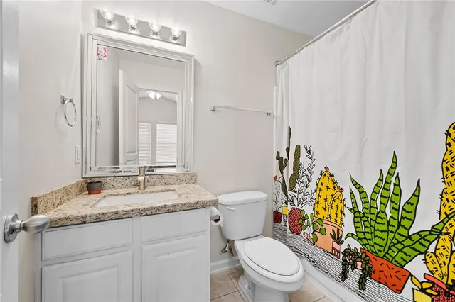 a bathroom with a granite countertop toilet sink and mirror