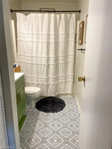 a bathroom with a sink a toilet a window and shower