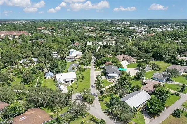 an aerial view of residential houses with outdoor space and trees