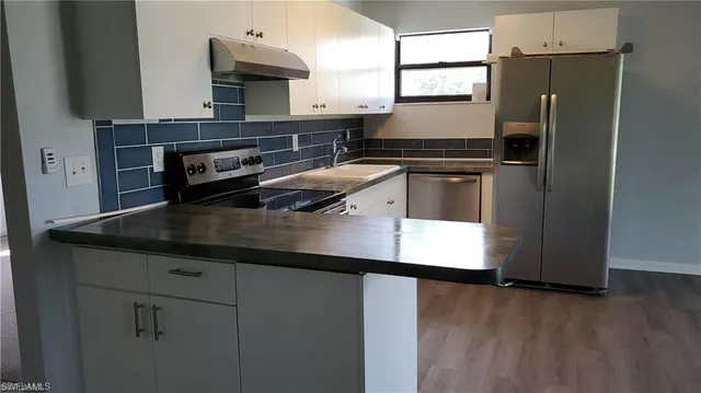 a kitchen with kitchen island a counter appliances a sink and cabinets
