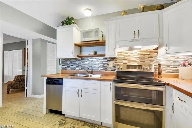 a kitchen with granite countertop a stove oven and white cabinets