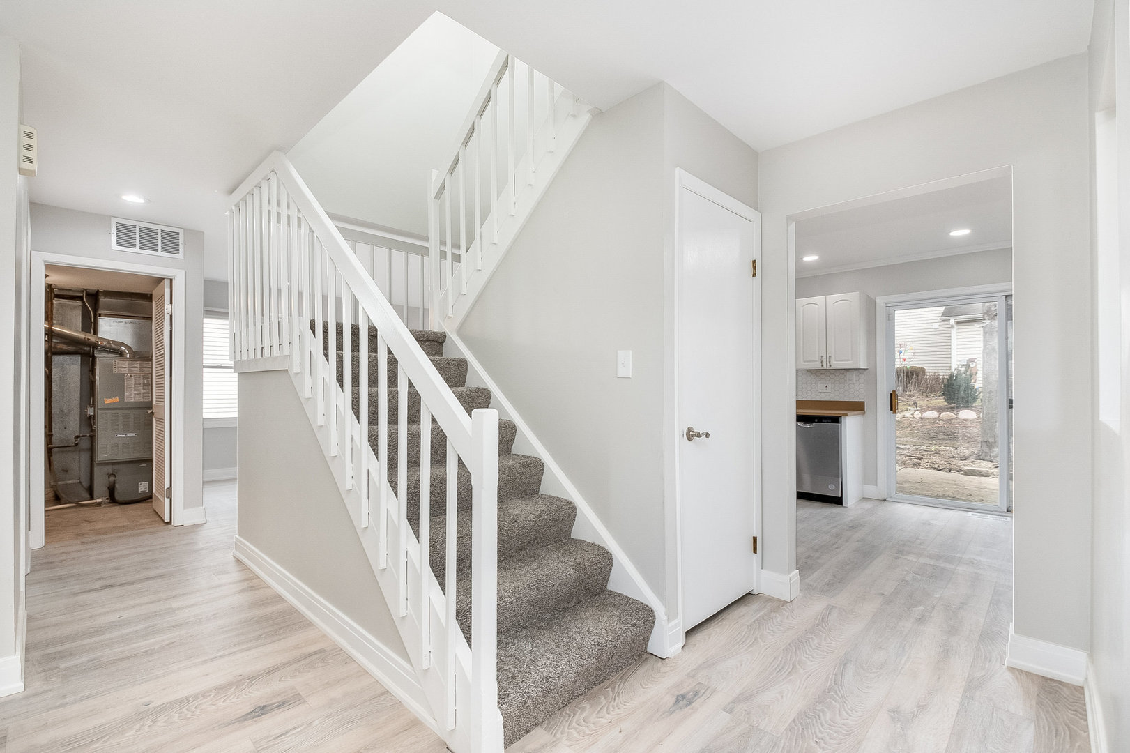 235 Hedgerow Drive Bloomingdale, IL 60108 - Photo 13 of 24 a view of a hallway with wooden floor kitchen view and staircase