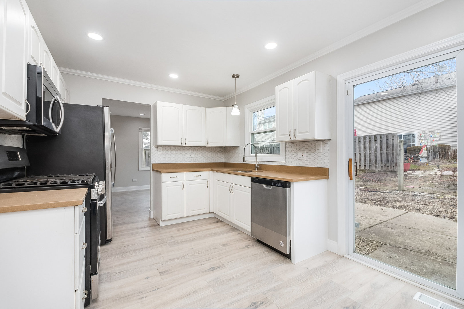 235 Hedgerow Drive Bloomingdale, IL 60108 - Photo 2 of 24 a kitchen with stainless steel appliances granite countertop a stove a sink a refrigerator and white cabinets with wooden floor