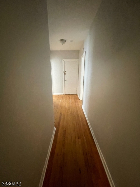 388 Leslie Street Newark, NJ 07112 - Photo 12 of 19 a view of a hallway with wooden floor