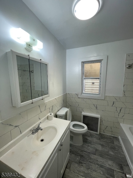 388 Leslie Street Newark, NJ 07112 - Photo 15 of 19 a bathroom with a sink toilet and mirror