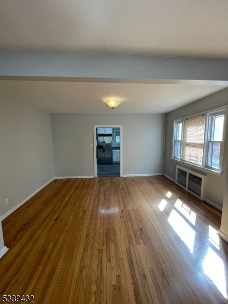 388 Leslie Street Newark, NJ 07112 - Photo 5 of 19 a view of empty room with wooden floor and fan
