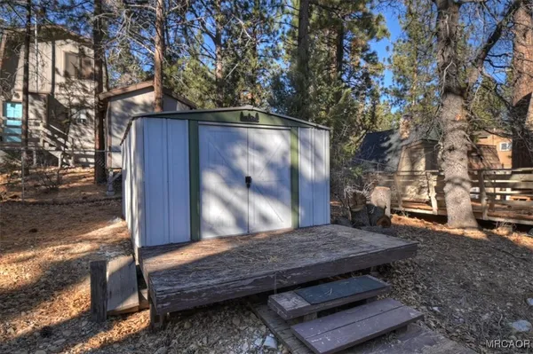a view of backyard with wooden fence and large trees