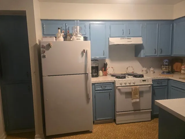 a kitchen with refrigerator and cabinets