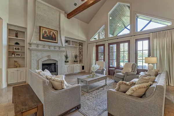 a living room with furniture a fireplace and a large window