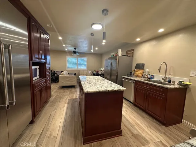 a kitchen with stainless steel appliances kitchen island granite countertop a stove and a refrigerator