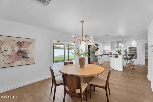 a dining room with furniture a chandelier and wooden floor