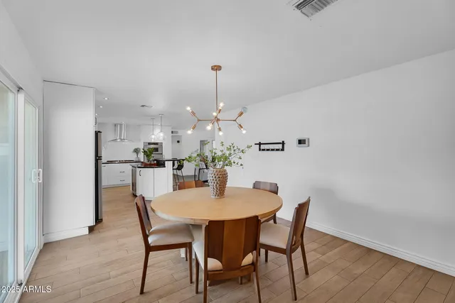 a dining room with furniture a chandelier and wooden floor
