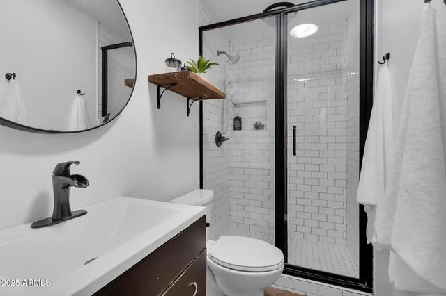 a bathroom with a sink a toilet and shower