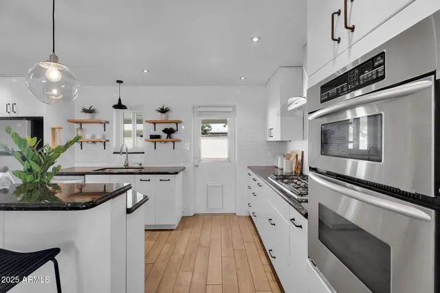 a kitchen with stainless steel appliances granite countertop a sink and stove