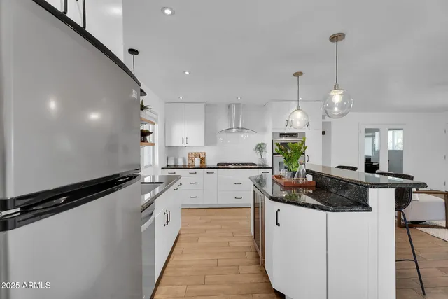 a open kitchen with stainless steel appliances granite countertop a sink a stove and a refrigerator