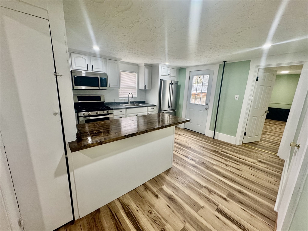 2 Wall Court Maynard, MA 01754 - Photo 2 of 11 a large kitchen with stainless steel appliances a refrigerator and a stove top oven