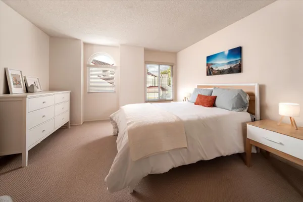 a spacious bedroom with a bed and a window