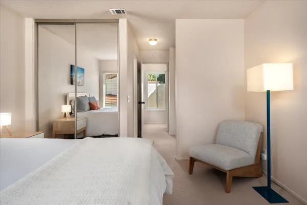 a bedroom with a bed mirror and couch