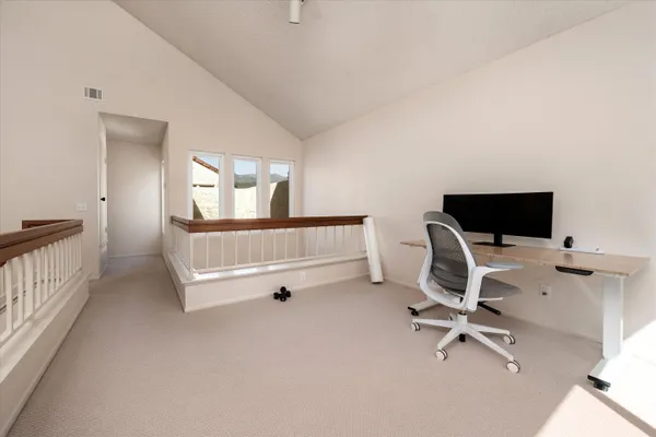 a view of a workspace with furniture and a window