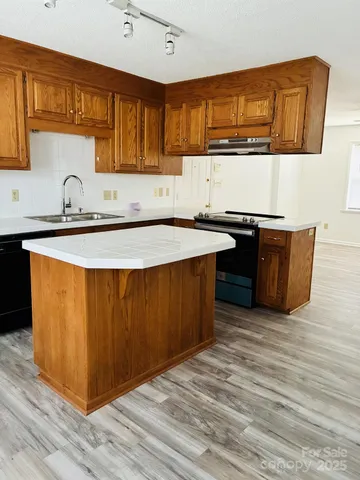 a kitchen with stainless steel appliances granite countertop a sink wooden cabinets and a granite counter tops