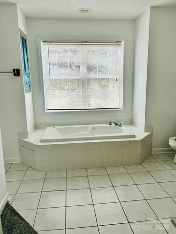 a spacious bathroom with a bathtub and window