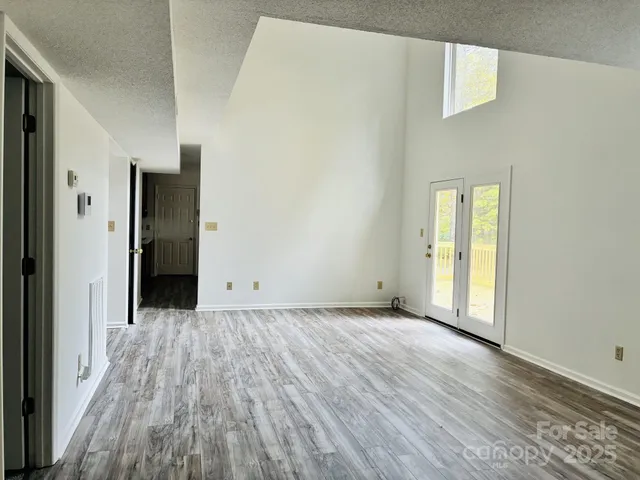 a view of a room with wooden floor and a bathroom