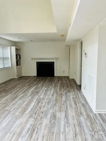 wooden floor fireplace and windows in an empty room