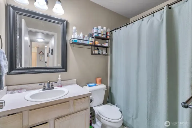 a bathroom with a sink a toilet and a mirror