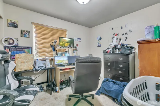 a view of a workspace with furniture and a window