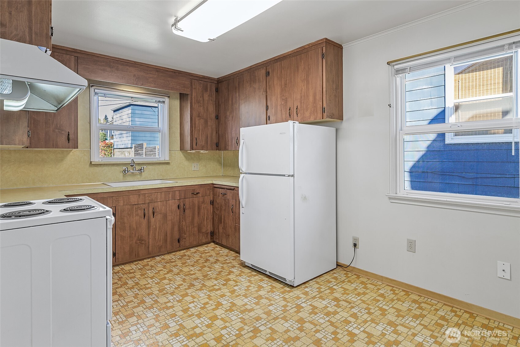 4437 47th Avenue Southwest Seattle, WA 98116 - Photo 17 of 39 a kitchen with a refrigerator and a stove top oven