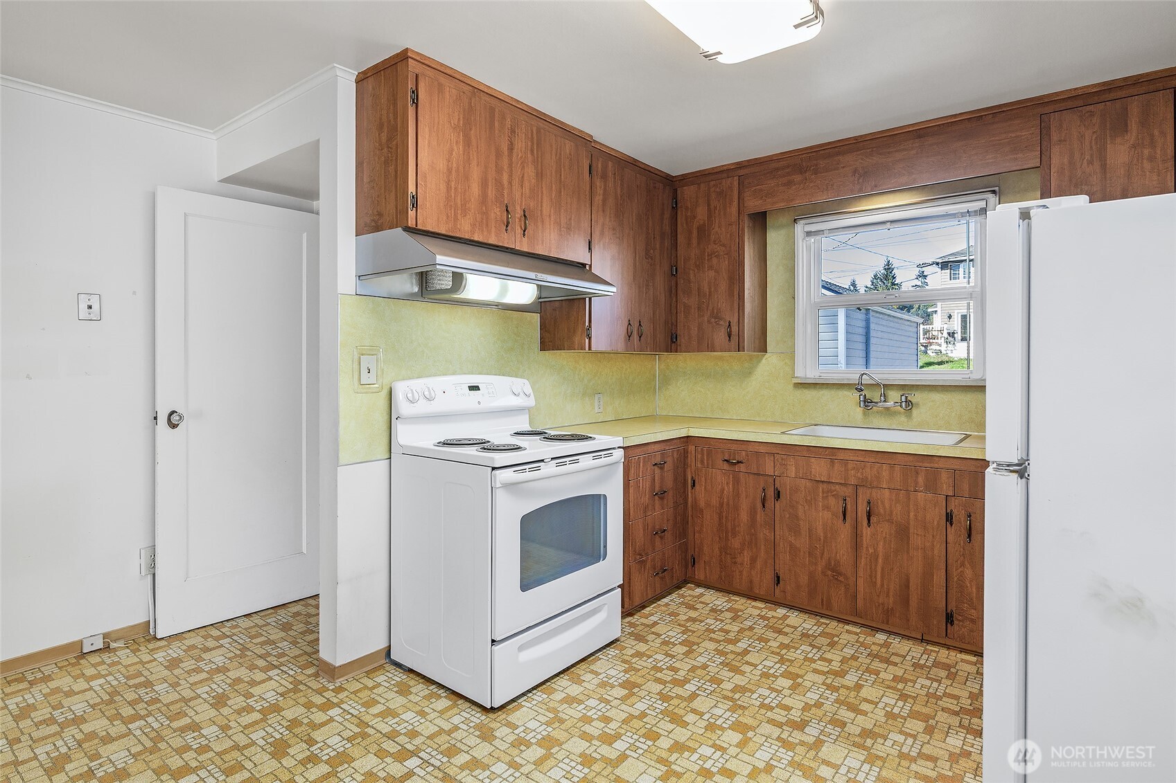 4437 47th Avenue Southwest Seattle, WA 98116 - Photo 18 of 39 a kitchen with a stove a sink and a refrigerator