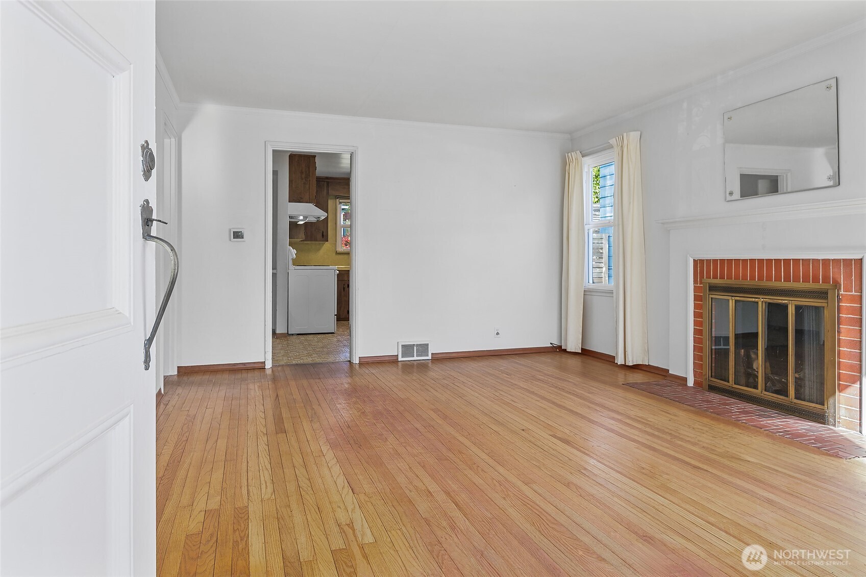 4437 47th Avenue Southwest Seattle, WA 98116 - Photo 7 of 39 a view of an empty room with wooden floor and a window