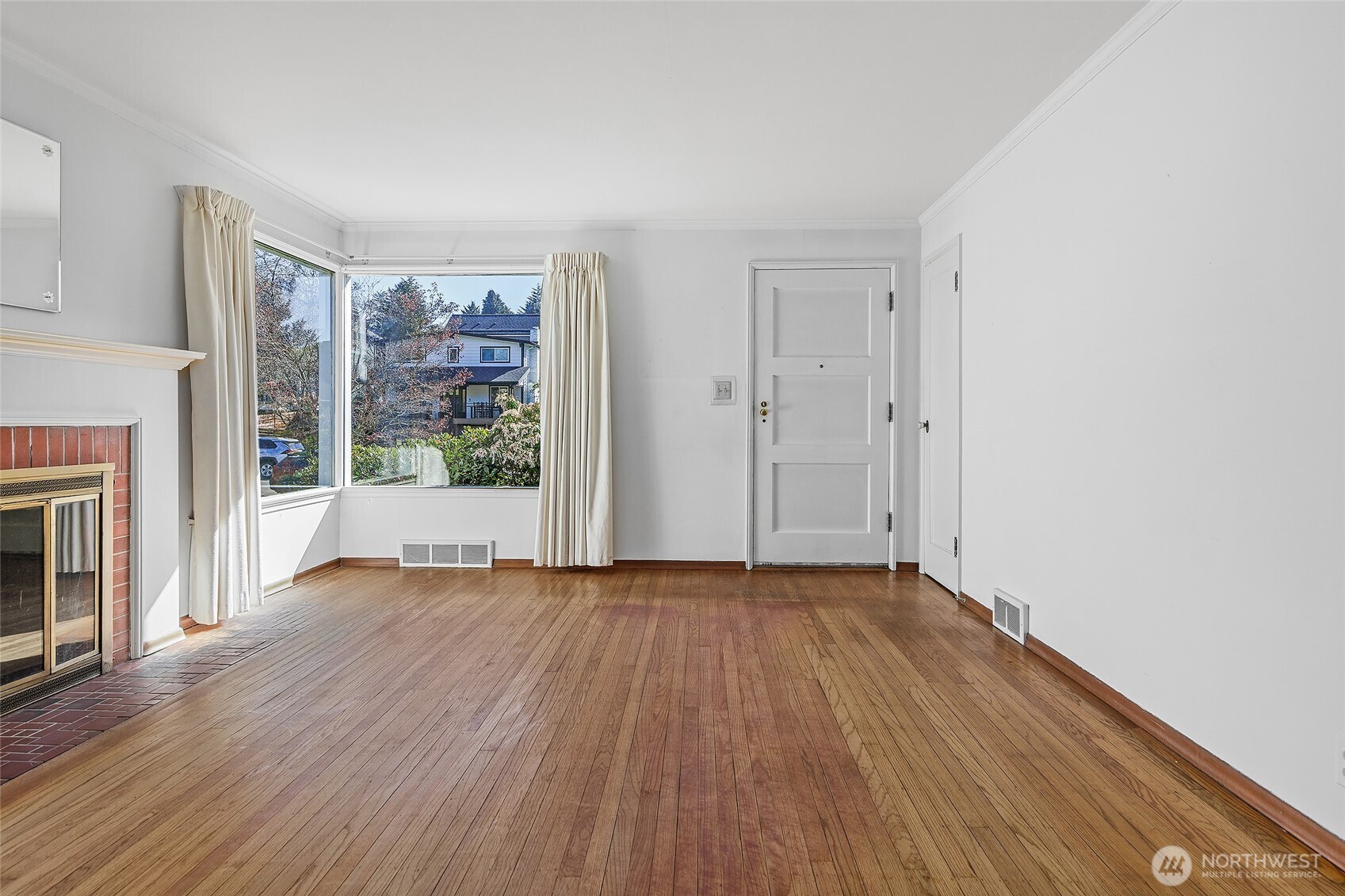 4437 47th Avenue Southwest Seattle, WA 98116 - Photo 9 of 39 a view of an empty room with wooden floor and a window