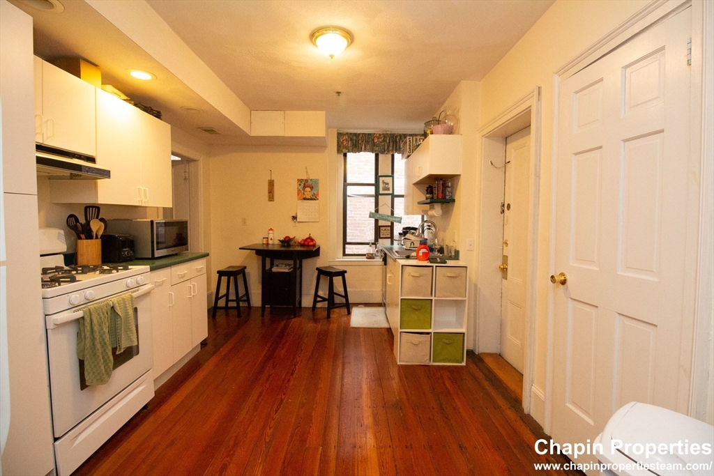 209 Washington Street, Unit 4 Brookline, MA 02445 - Photo 3 of 8 a kitchen with stainless steel appliances a stove top oven a sink dishwasher and a refrigerator