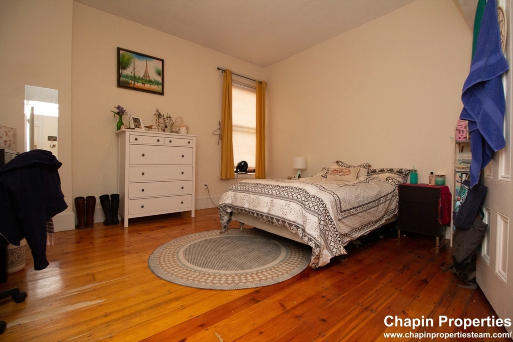 209 Washington Street, Unit 4 Brookline, MA 02445 - Photo 6 of 8 a bedroom with a bed and wooden floor