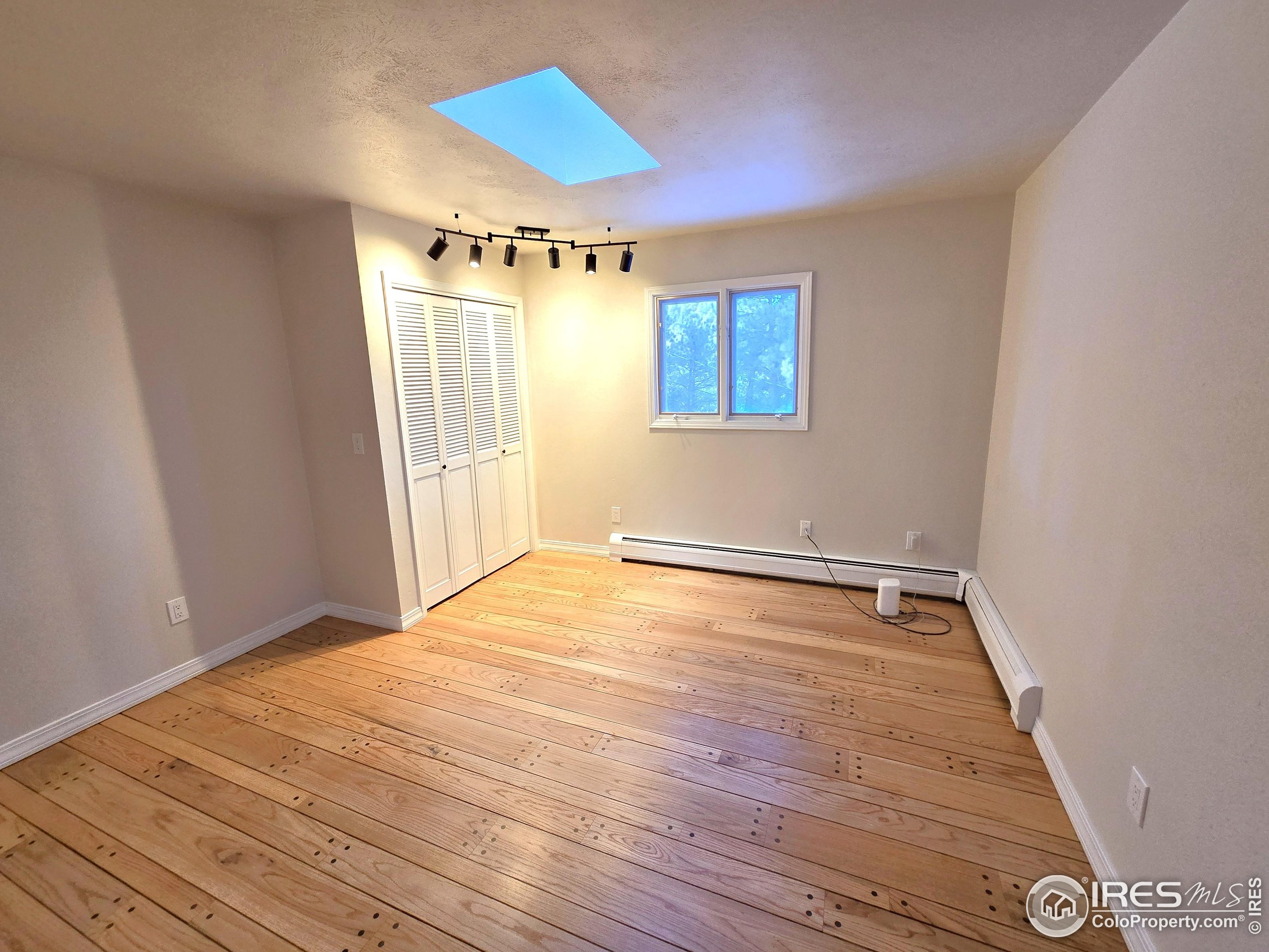 76 Pine Tree Lane Boulder, CO 80304 - Photo 19 of 49 a view of an empty room with wooden floor and a window